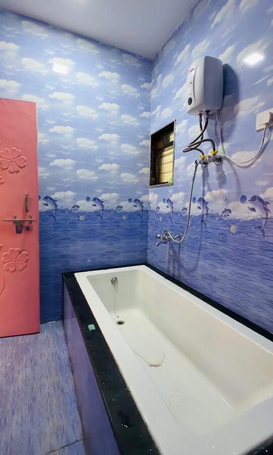Cottage bathroom with cloud and dolphin tiling and a tub