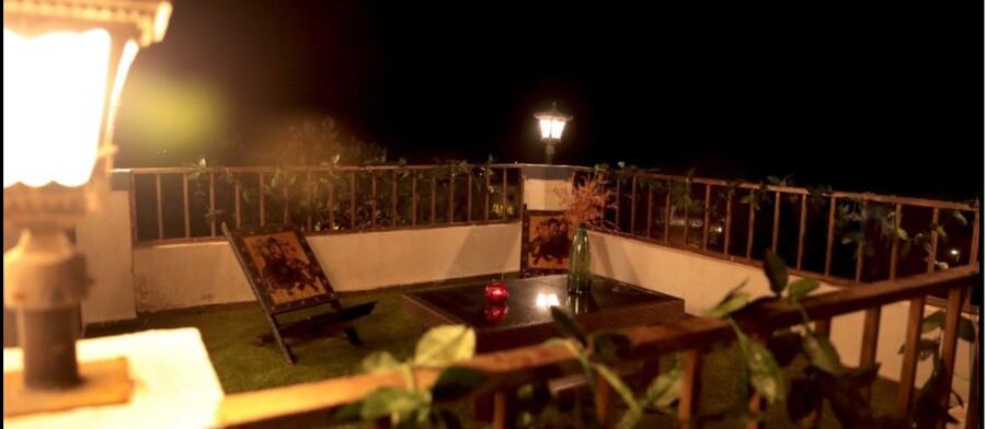 Rooftop terrace lit by lanterns at night