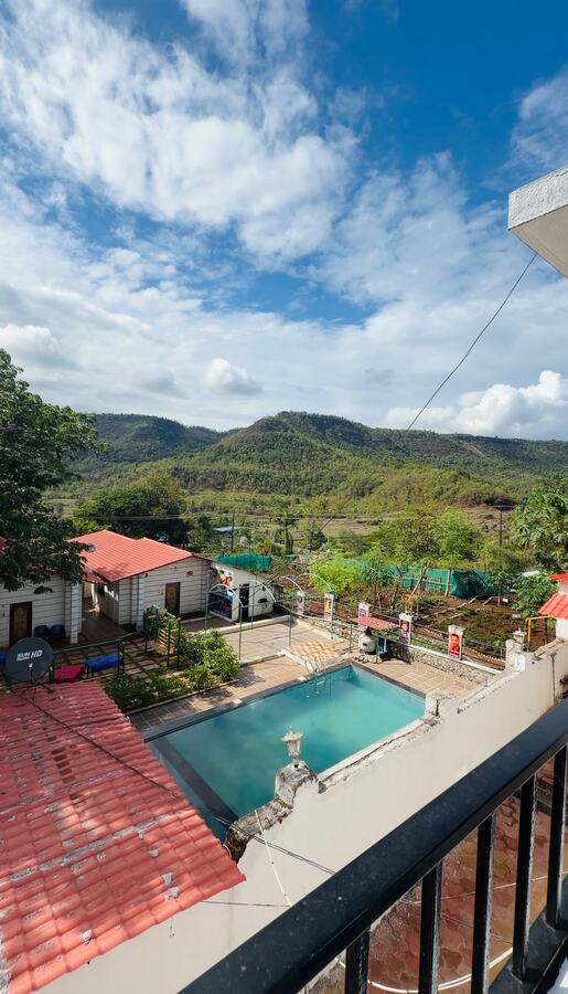 Balcony view over the pool and Sahyadri hills at White House